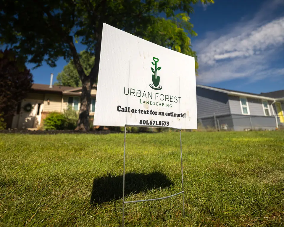 Lawn sign with Urban Forest Landscaping logo and contact information